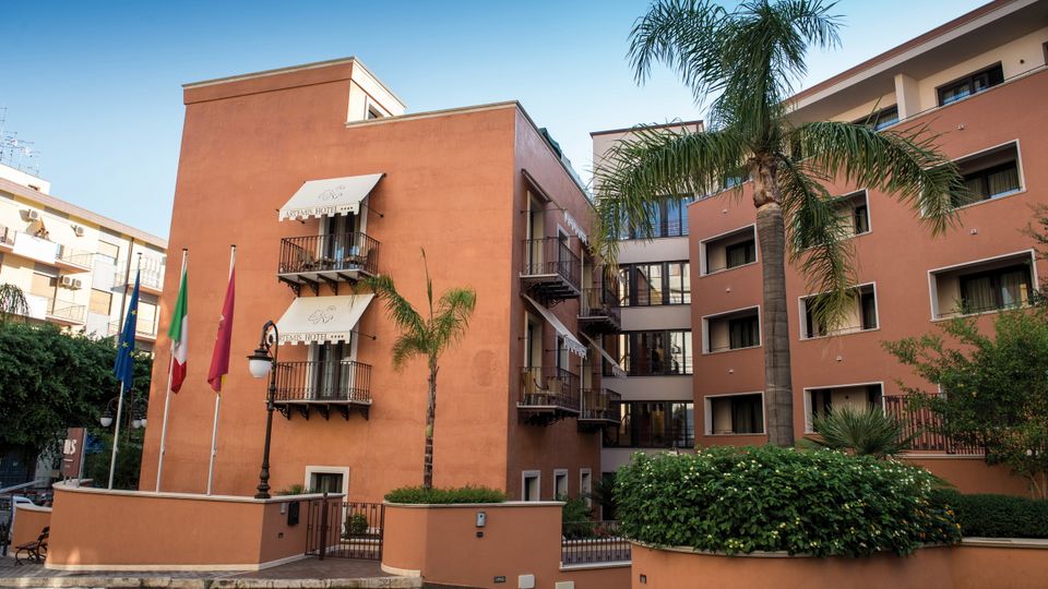 Sizilien Hotel Artemis außen ©michelangelo_int_travel Einladende Außenansicht des Artemis Hotels mit mediterranem Flair, Palmen und kleinen Balkonen – zentral gelegen für einen entspannten Urlaub in Italien.