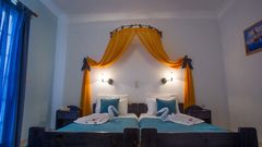 Gemütliches Zimmer mit liebevollen Details, farbenfrohem Baldachin und dekorativ gefalteten Handtüchern – ideal für einen charmanten Aufenthalt in familiärer Atmosphäre.