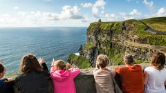 Touristen sehen auf die Cliffs of Moher