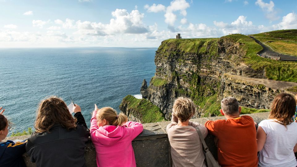 Touristen sehen auf die Cliffs of Moher