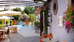 Lipari Hotel Arciduca ©michelangelo int travel, momento Stilvoll gestalteter Innenhof mit kleinem Brunnen, bunten Wanddekorationen, gemütlichen Sitzplätzen und mediterraner Bepflanzung – lebendige Farben und liebevolle Details sorgen für ein einladendes Ambiente.