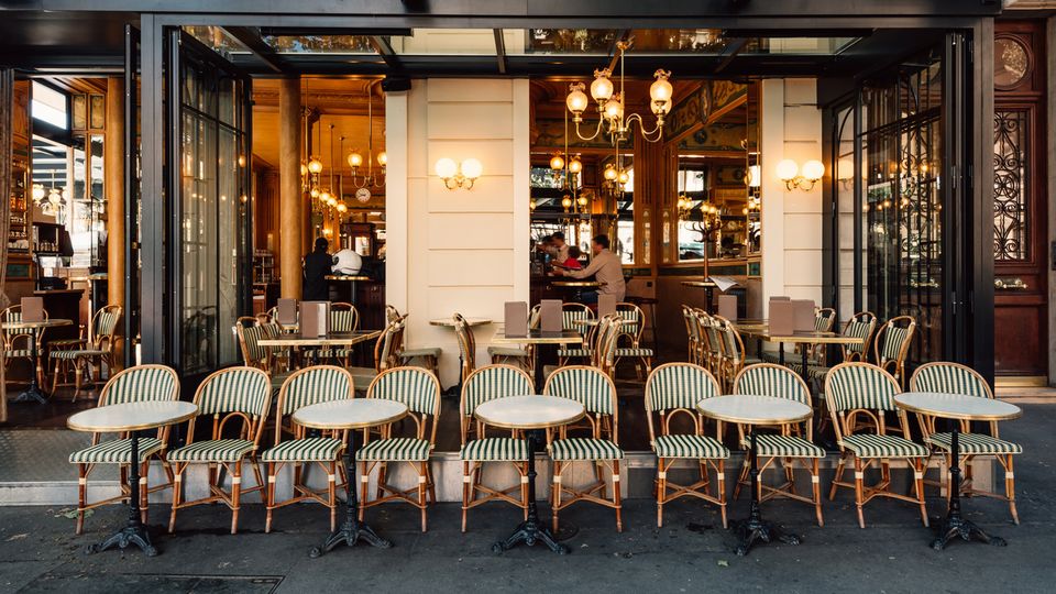 Typische Straßenszene in Paris mit den Tischen einer Brasserie (Café)