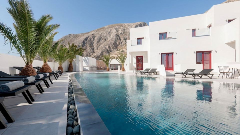 4*-Hotel MAR n MAR Crown Hotel & Suites Außenansicht ©MAR n MAr Crown Hotel & Suites - momento Moderner Poolbereich mit stilvollen Liegen und Palmen, umgeben von weißer Architektur und beeindruckender Bergkulisse – ideal zum Entspannen unter der griechischen Sonne.