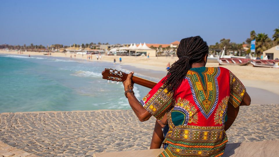 Musician with guitar and rasta hair at Santa Maria Beach, Sal